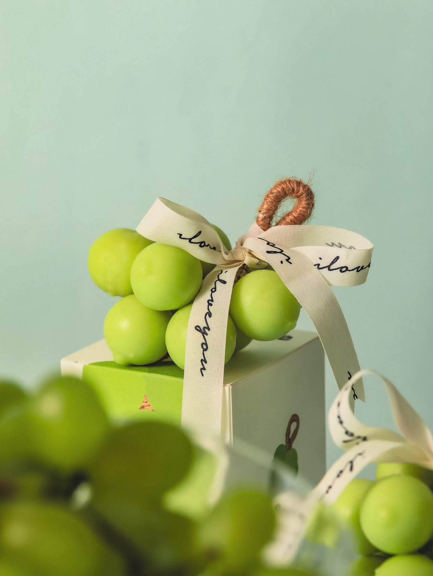 Realistic green grape cluster fruit soy candle in premium gift packaging box