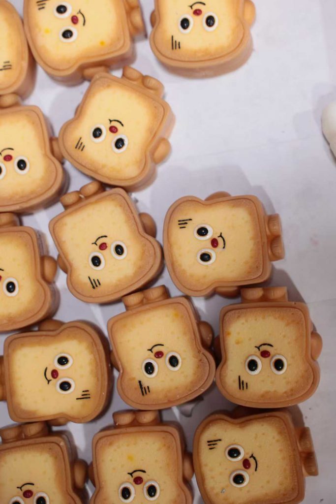Batch production of custom cute toast shaped novelty soy candles at BSCI-certified factory for wholesale private label gift brands.